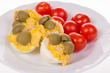 stuffed eggs and red little tomatoes on a pot