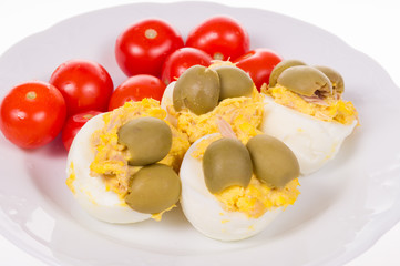 stuffed eggs and red little tomatoes on a pot
