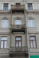 Old balcony with stucco mouldings and bars on the building