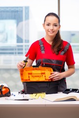 Young woman in coveralls doing repairs