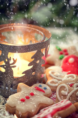 Christmas decoration with gingerbread cookies and glowing candle 