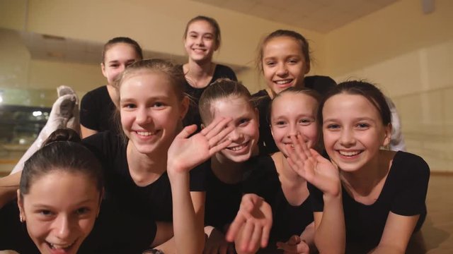 young ballerinas sitting on the floor and looking to the camera with smiles