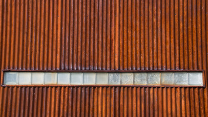 Rusty, Corrugated Metal Wall with a Row of Textured Glass Blocks