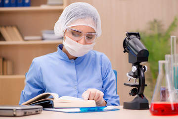 Lab chemist working with microscope and tubes