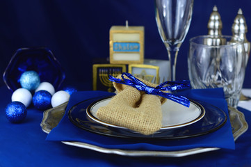 Place setting in varying shades of blue for Hanukkah. Includes shiny crystal glasses, silver salt and pepper shakers, cute holiday candles and sparkling decorations. Shallow depth of field. - Powered by Adobe