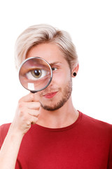 man holds on eye magnifying glass looking through loupe