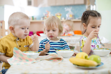 little kids eating in kindergarten