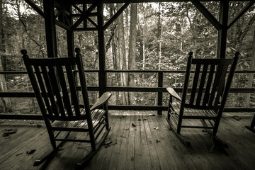 Two Empty Rocking Chairs. Two wooden rocking chairs on an old front porch. Shot in black and white...