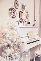 Xmas interior design includes white decorated Christmas tree with hand made ornaments and white piano. Winter scene. New Year decoration.