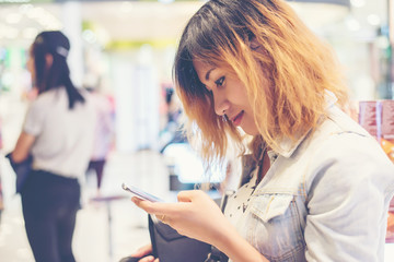 young beautiful woman wearing jean jacket texting on the smartph