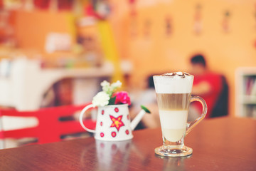Cup of coffee with flower lobe pattern in reveal cup on wooden t