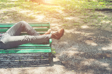 Hipster guy lying down on bench with  jeans and brown chamois sh
