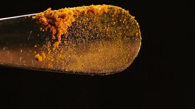 A tea spoon with yellow orange Turmeric