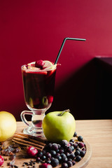 A nice glass of mulled wine with cinnamon sticks and apples