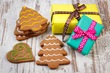 Decorated gingerbread and gifts for Christmas on old wooden background, christmas time