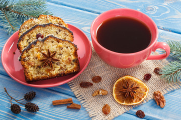Cup of coffee, fresh baked fruitcake for Christmas and spruce branches