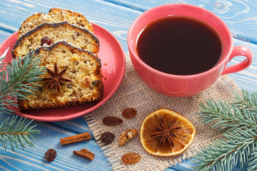 Cup of coffee, fresh baked fruitcake for Christmas and spruce branches