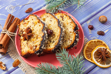 Fresh baked fruitcake for Christmas on plate and spruce branches on boards