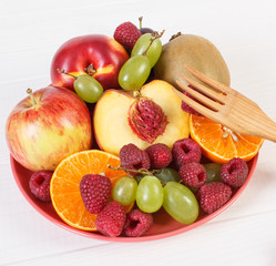 Fresh ripe fruits on plate lying on white boards