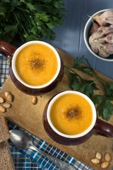 pumpkin cream soup in mugs on  gray blue background