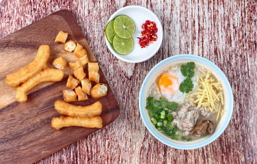 Rice porridge with mined pork and chicken lever served with side dish as Patongko (deep-fried dough stick) and spicy sour filling.