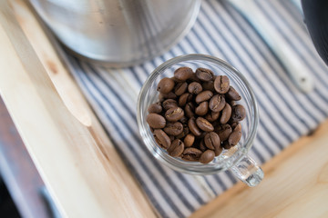 The raw coffee beans in the glass cup.