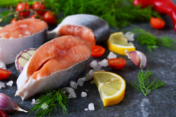 Fresh raw salmon steak with lemon and salt on black marble 