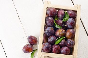 Wooden crate with plums