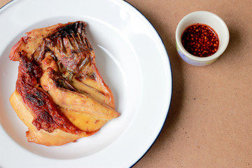 Grilled chicken breast in white dish on wooden table