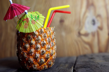pineapple with straw wooden background