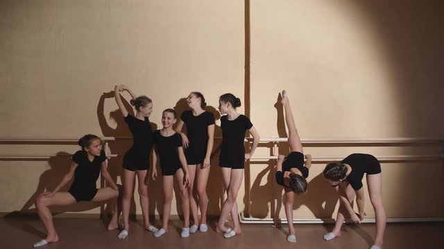 group of four young ballerinas standing in row and practicing ballet