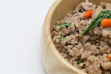 Minced pork and chilli with Basil leaves in wooden bowl isolated