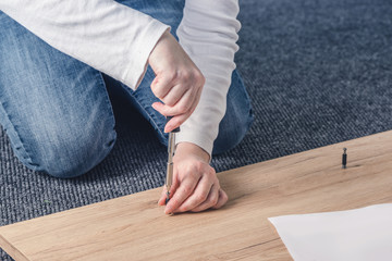 Woan assembling furniture at home, hand with screwdriver