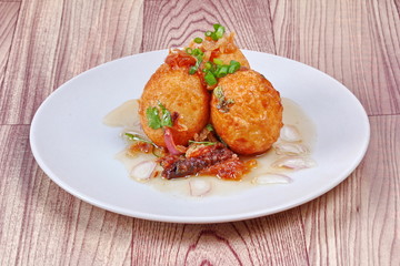 Fried hard-boiled eggs with tamarind sauce call as Khai Luk Keoi in Thai ,which mean egg gift  from...