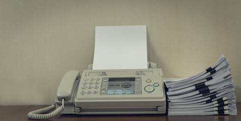 old fax machine on the table and stack of paper. - obrazy, fototapety, plakaty