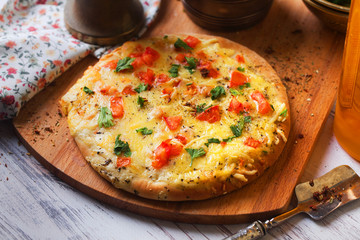 homemade pizza with a mini board tomatoes and herbs
