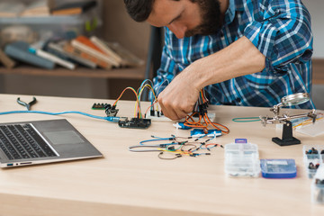 Engineer creating electronic construction at lab. Hacker conduct experiment with computer...