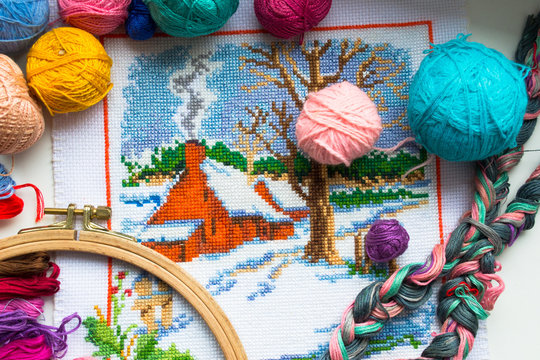Embroidered winter house with yarn for colour knitting and tambour