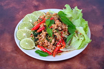 Thai food,Fried spicy basil with minced pork topped sliced green lemon and and lettuce .