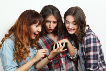 Funny girl looking to the phone. Friendship concept, life style, happiness, emotions