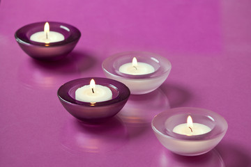 Obraz na płótnie Canvas burning candles on purple background