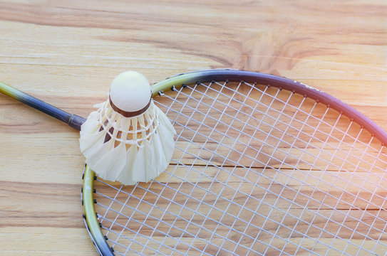 badminton ball, shuttlecock with racket on court floor, black an