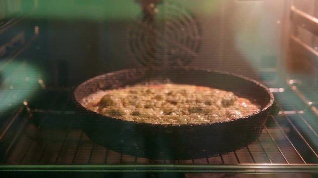 Cooking the pizza on the pan in the oven. Timelapse.