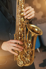 Young man in a suit hold a saxophone musical instrument
