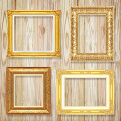 The antique gold frame on wooden wall background