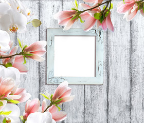 Magnolia flowers with orchidea and photo frame  on background of shabby wooden planks in rustic style
