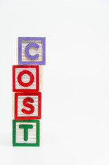 COST word wooden block arrange in vertical style on white background and selective focus