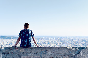 young man with the city bellow him