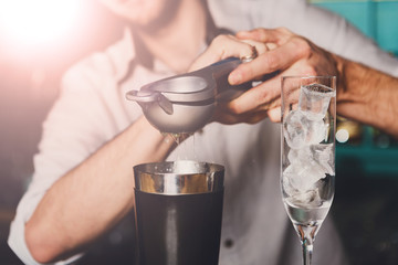 Barman's hands making cocktail with lime