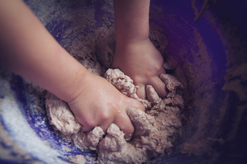 Child hands in baking dough